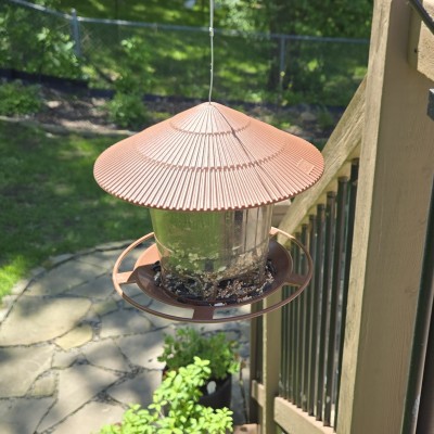 bronze colored bird feeder hanging off the side of a deck railing