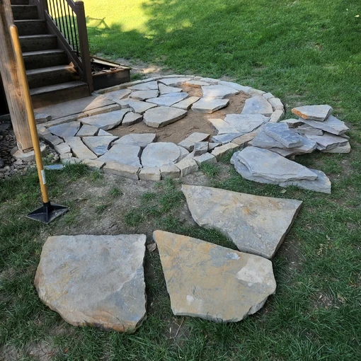 a flagstone patio being installed showing the process of installing each individual piece so it fits in the patio design.